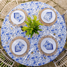 Table setting with plates, napkins, and cutlery on a floral tablecloth.