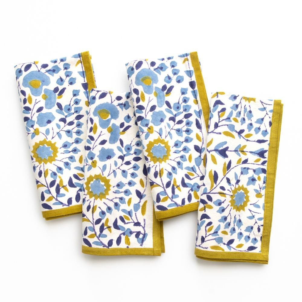 Set of four floral-patterned towels with yellow edges on a white background