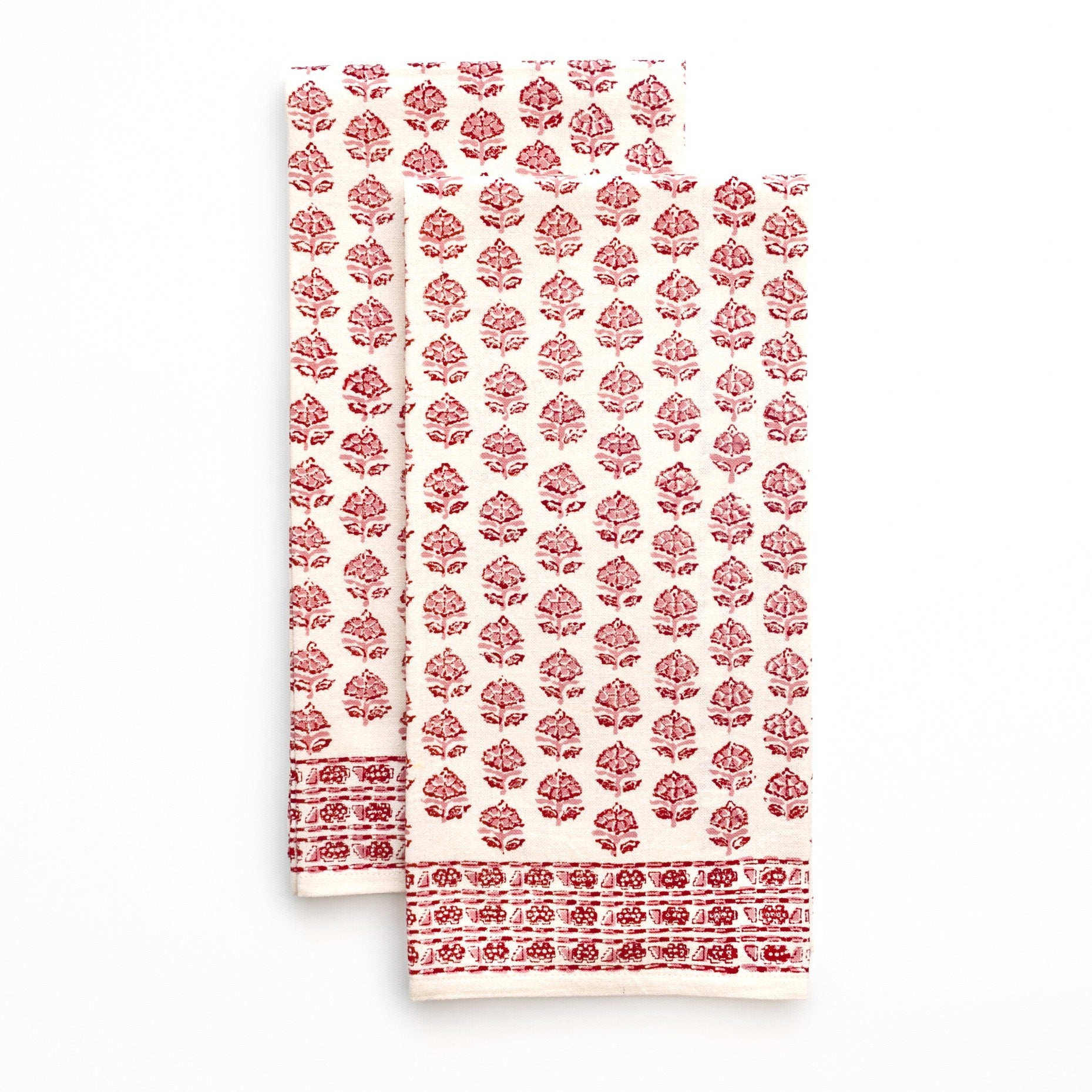 Two red floral patterned tea towels on a white background