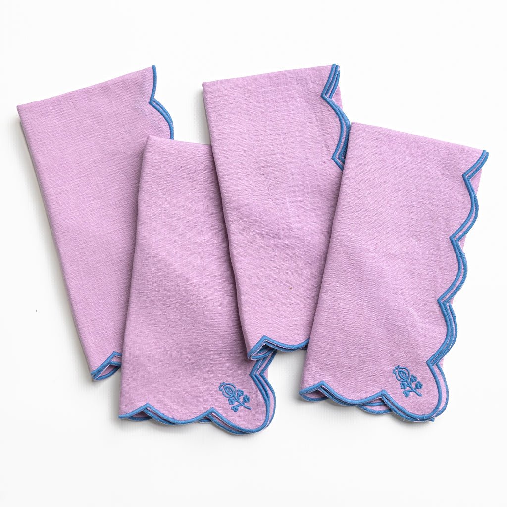 Set of four pink handkerchiefs with blue trim on a white background