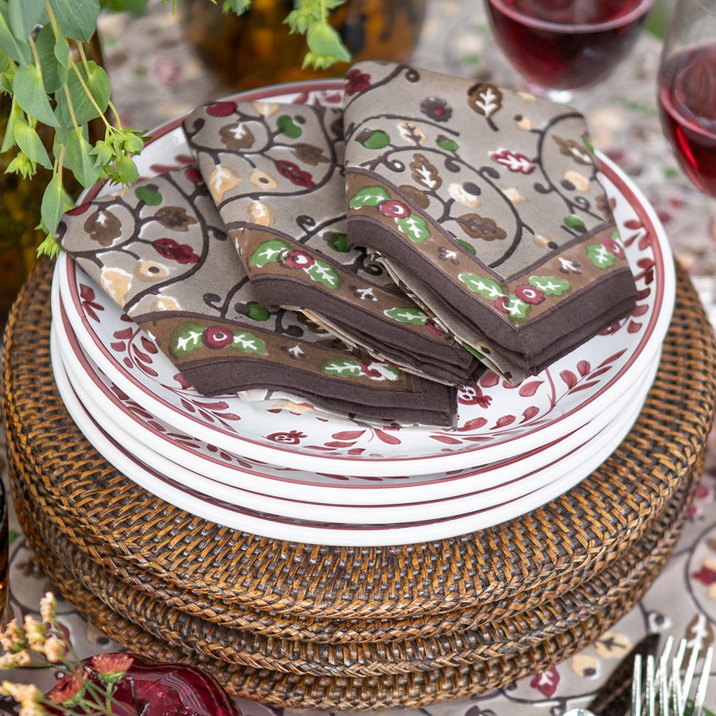 Decorative plates with floral patterns on a woven placemat.