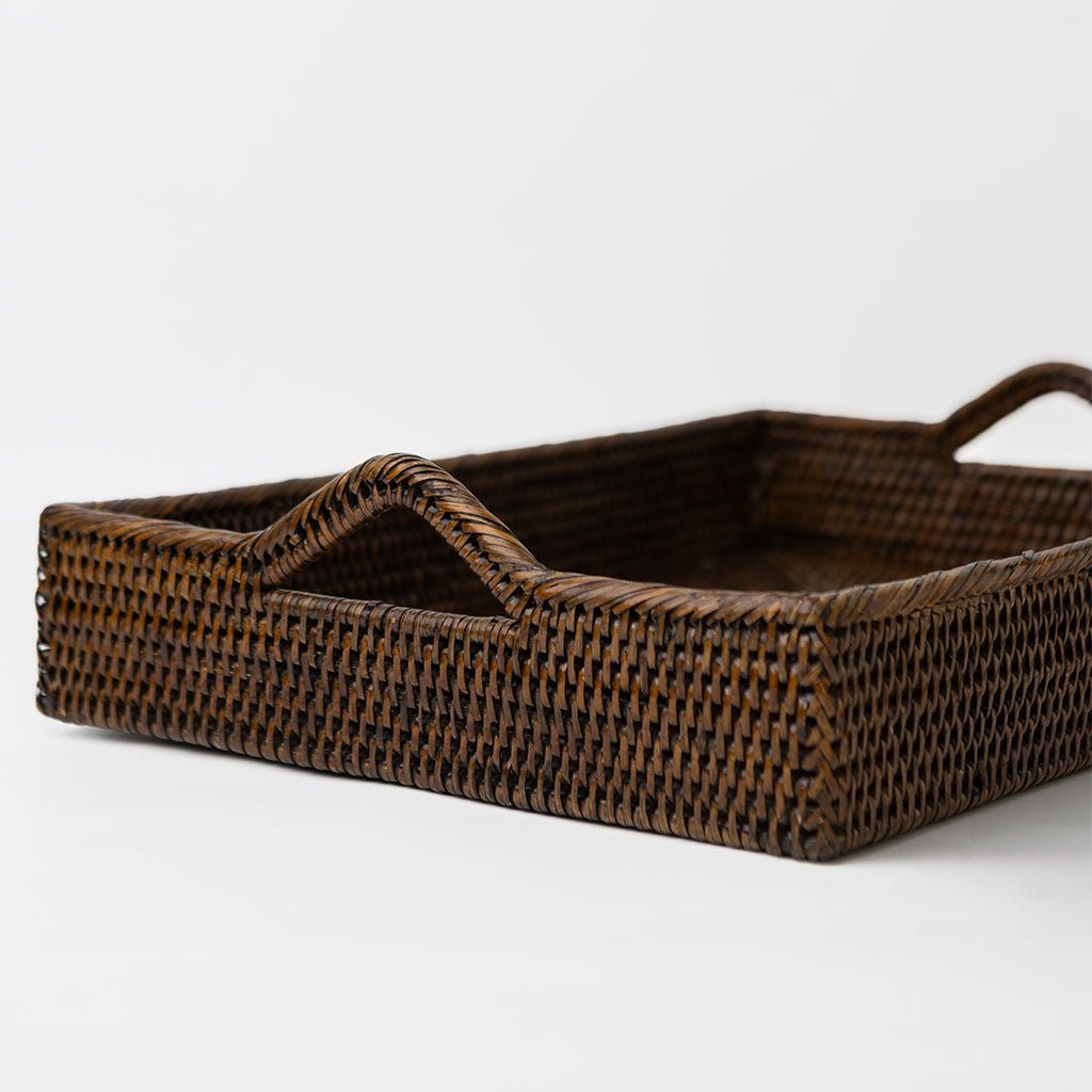 Woven brown tray with handles on a white background