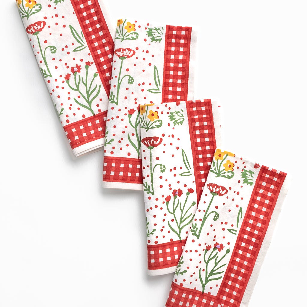 Set of cloth napkins with floral and checkered patterns on a white background