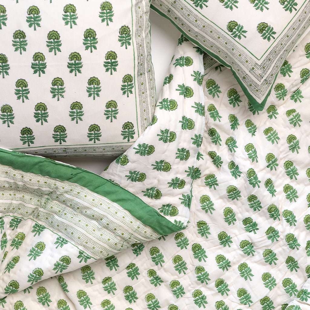 Green and white patterned bedding set on a bed