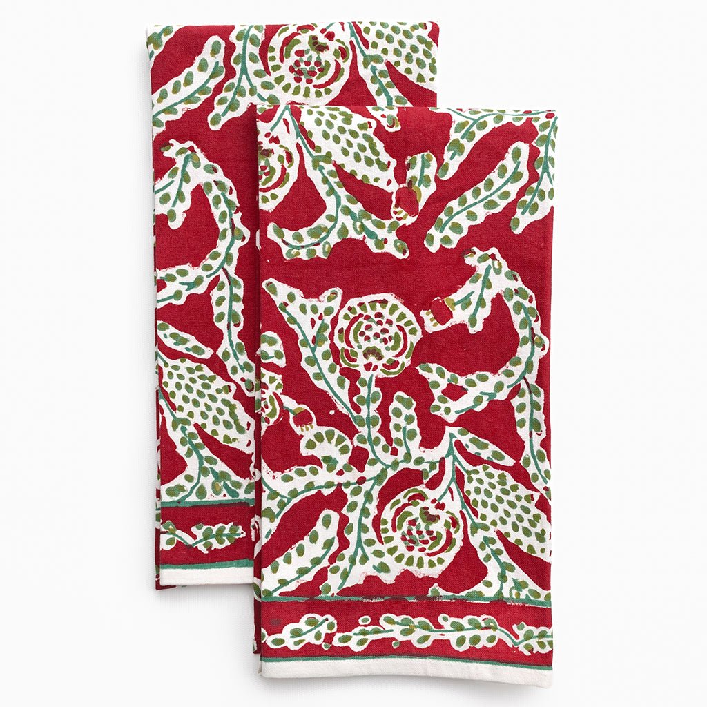 Two red and green patterned towels on a white background
