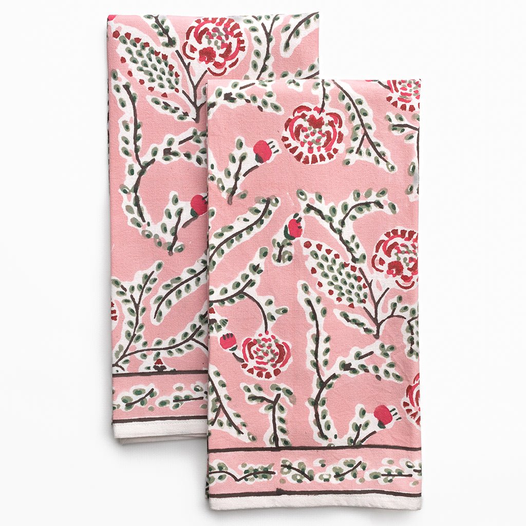 Two pink floral patterned towels on a white background