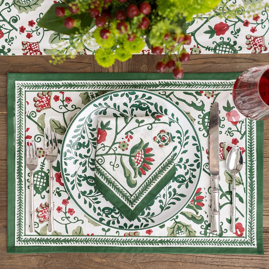 Decorative table setting with a plate, cutlery, and floral centerpiece on a patterned placemat.