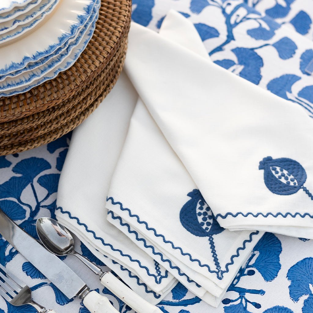White plates and napkins with blue floral patterns on a matching tablecloth.