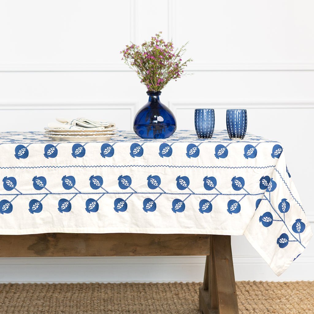 Tablecloth with blue floral pattern on a wooden table with decorative items.