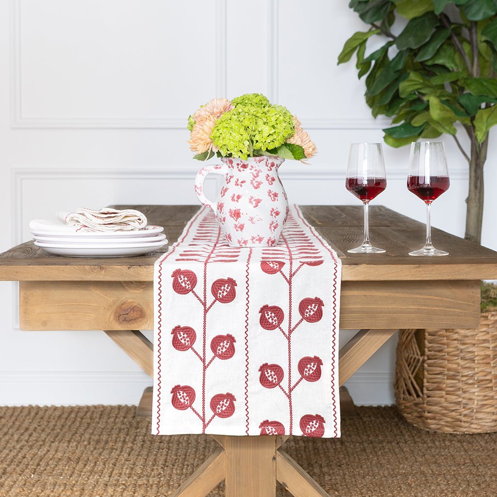 Table setting with a floral arrangement, wine glasses, and a decorative table runner.