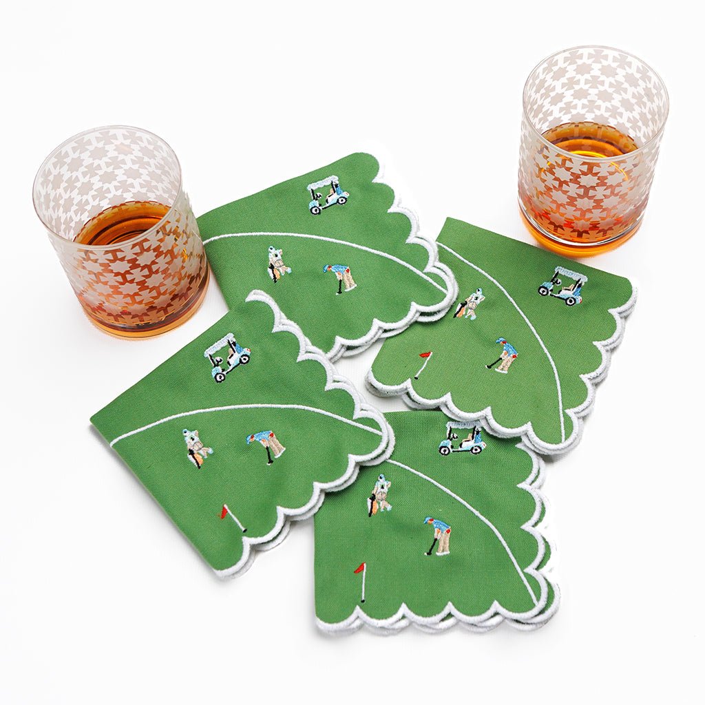 Set of four golf-themed napkins with miniature golf figures on a white background.