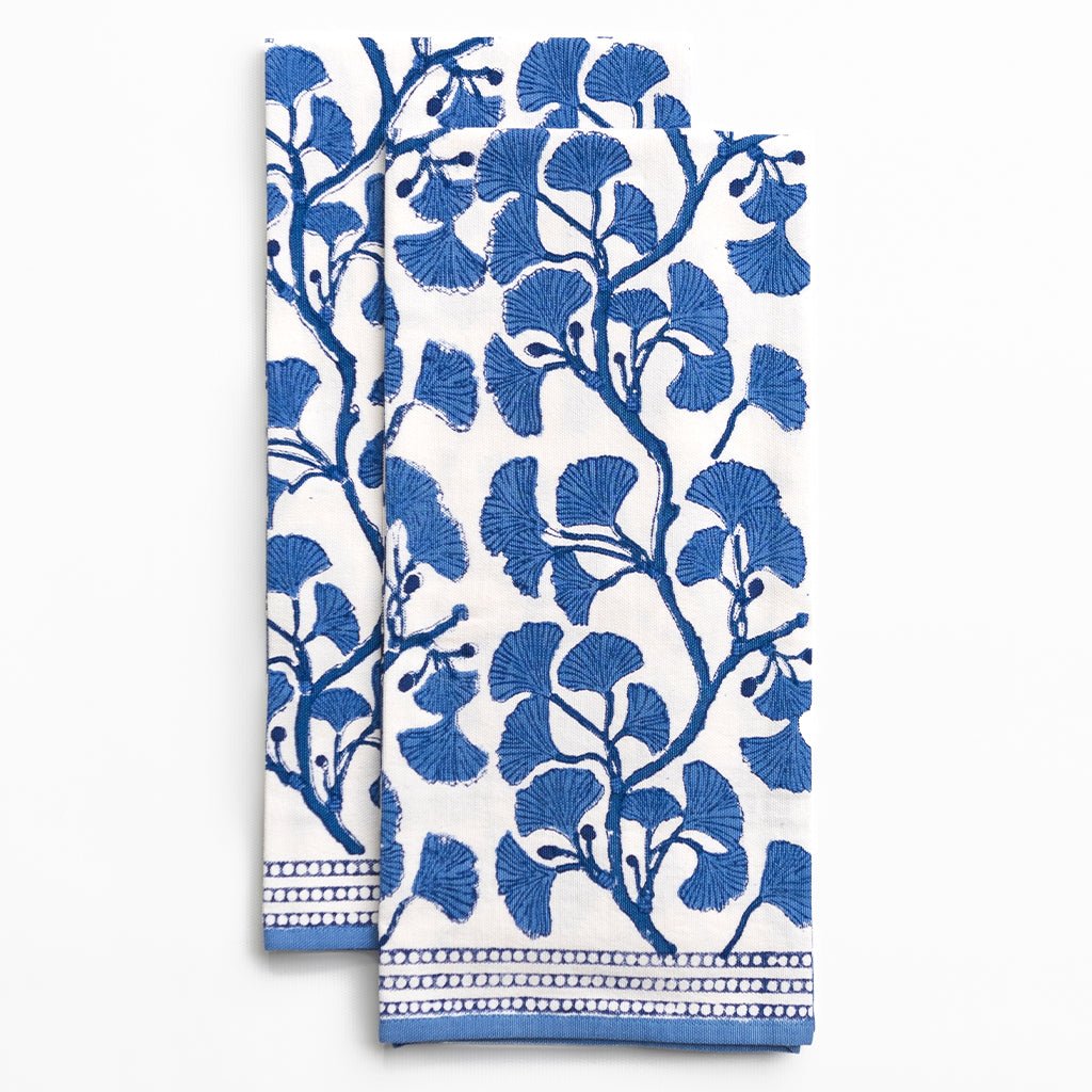 Two blue floral patterned towels on a white background