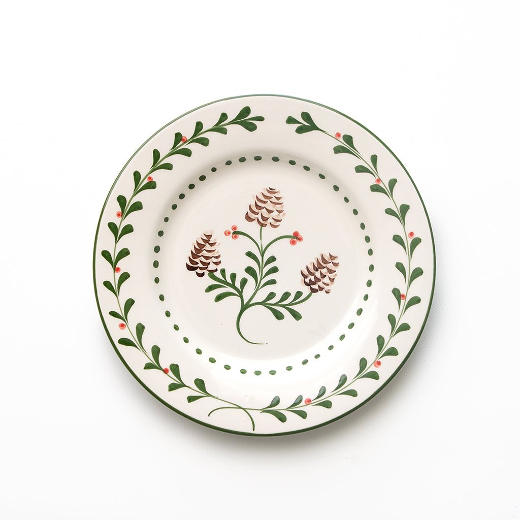 Decorative plate with floral and pine cone design on a white background