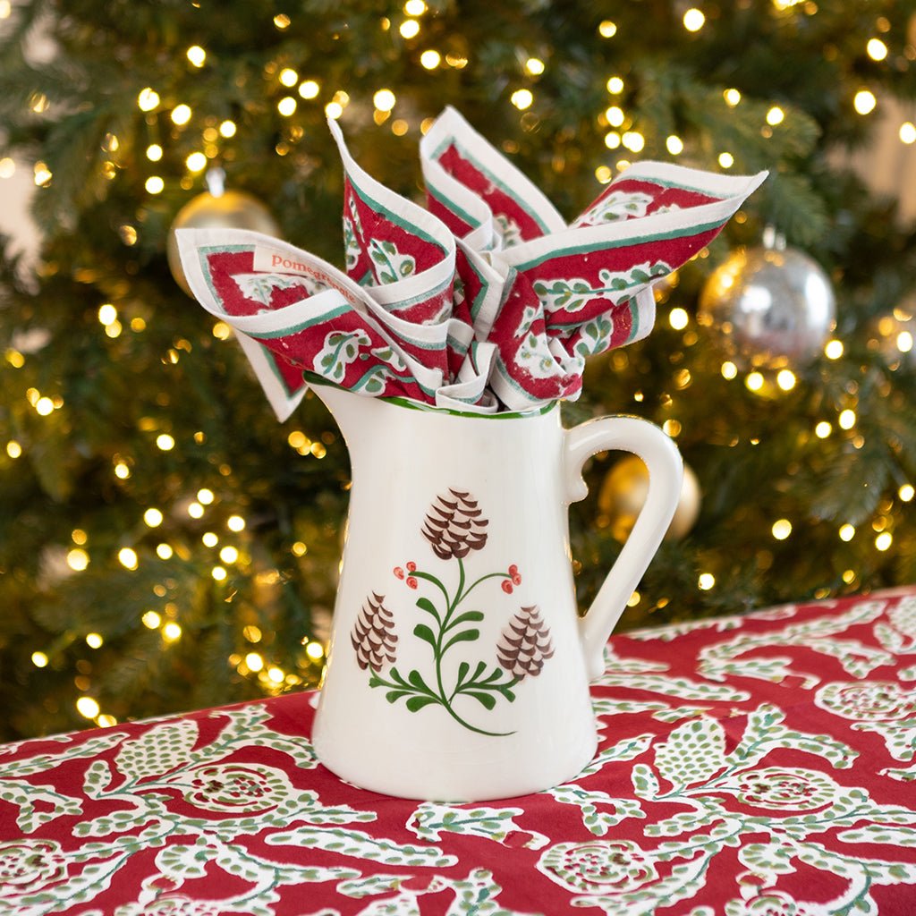 Ceramic pitcher with acorn pattern with festive background.