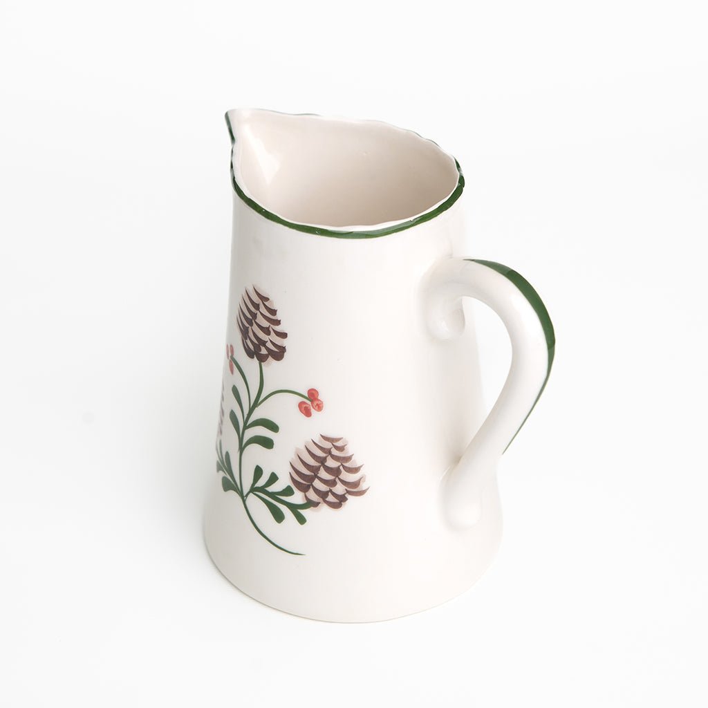 Ceramic pitcher with floral design on a white background