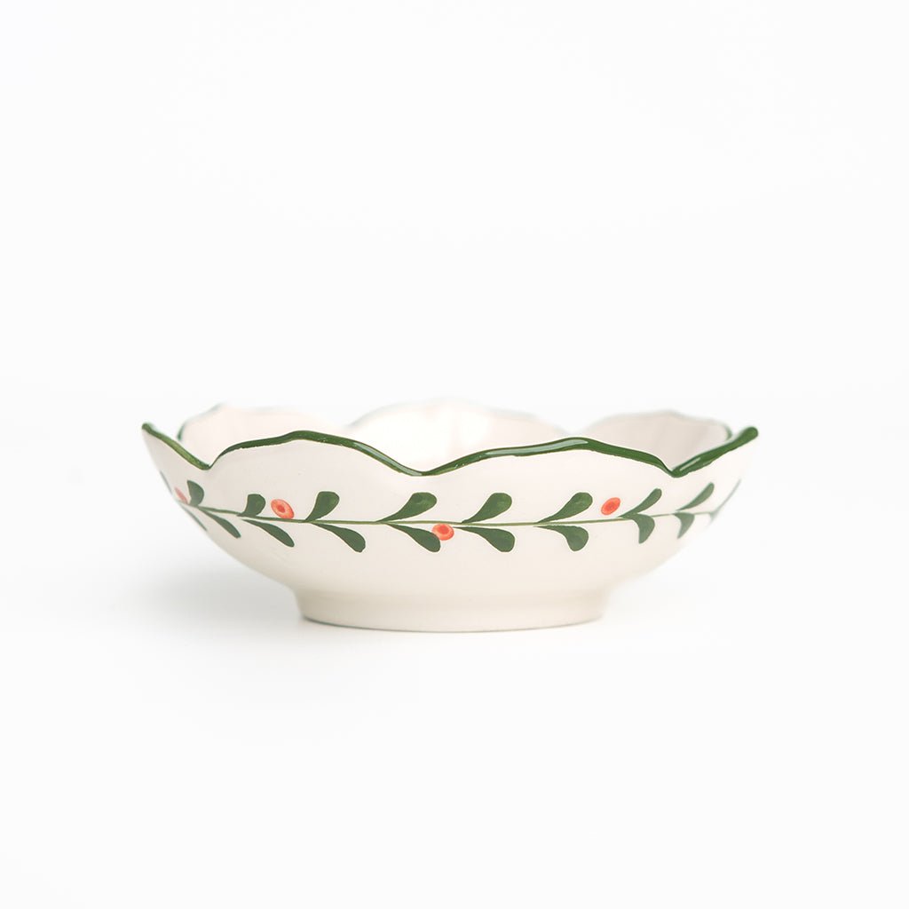 Decorative ceramic bowl with green leaf pattern on a white background