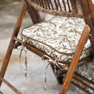 Wooden chair with a patterned cushion and decorative ribbon on a blurred background