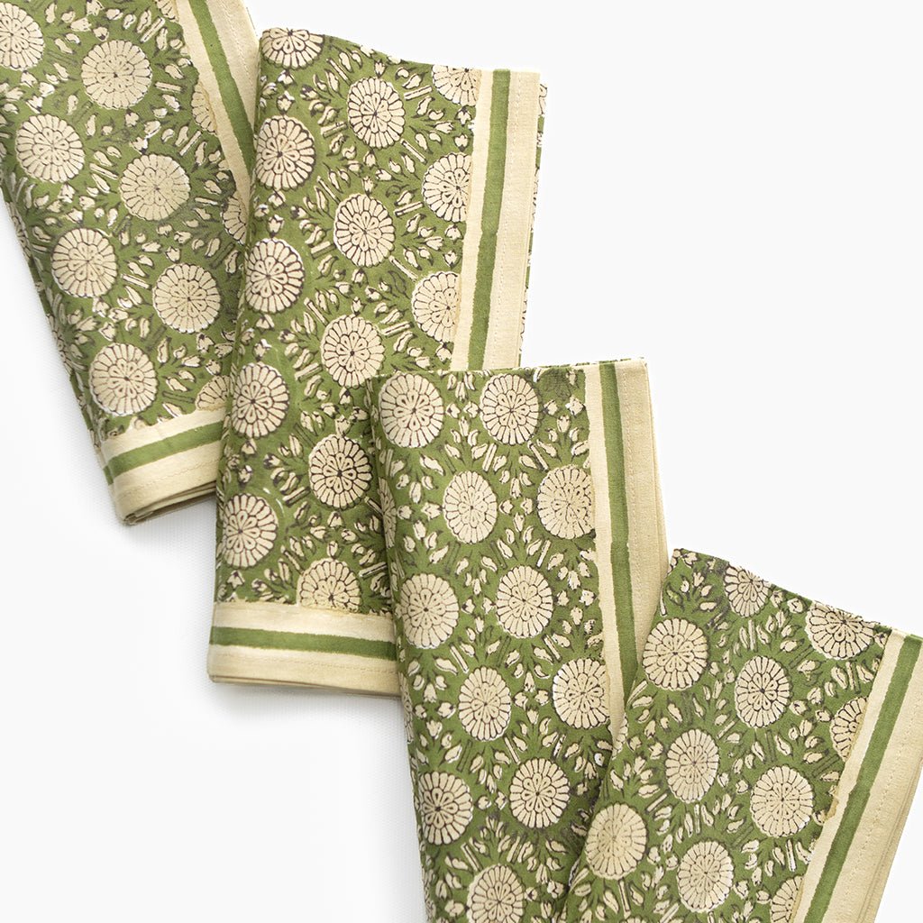 Set of green and beige patterned napkins on a white background