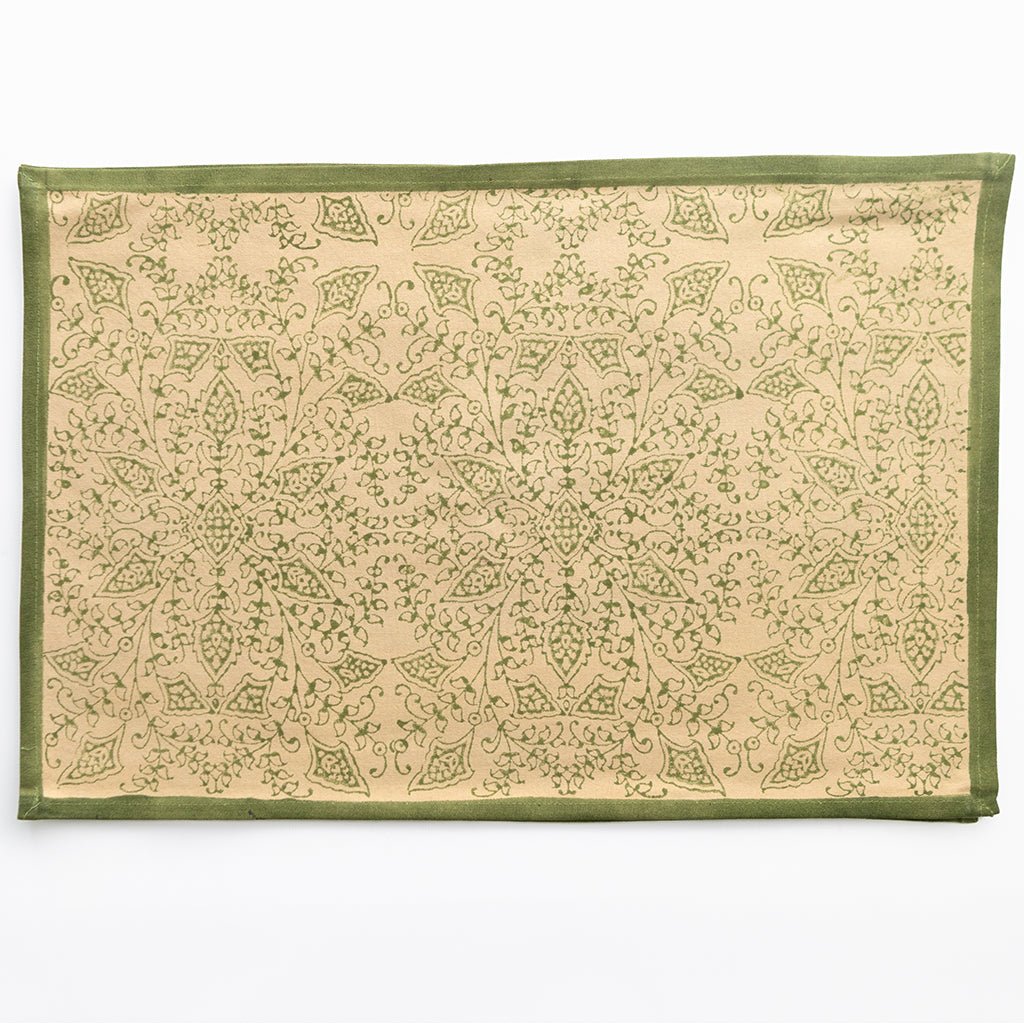 Decorative mat with green border and intricate pattern on beige background