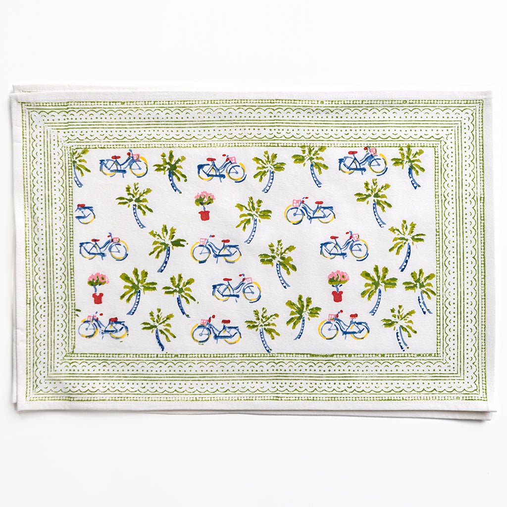 Decorative placemat with bicycle and palm tree pattern on a white background