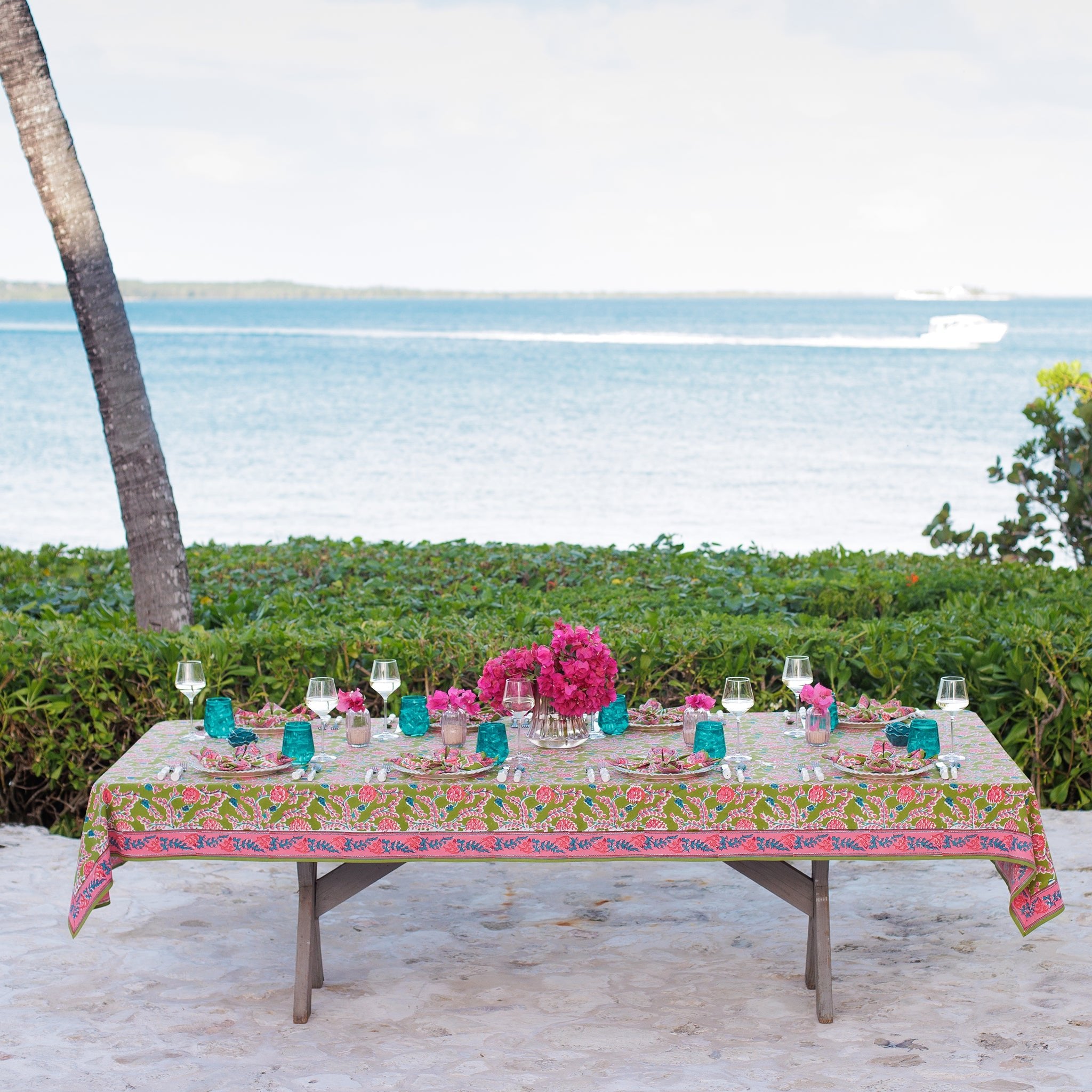 Green & pink pinecone botanical block printed tablecloth with a scenic ocean background
