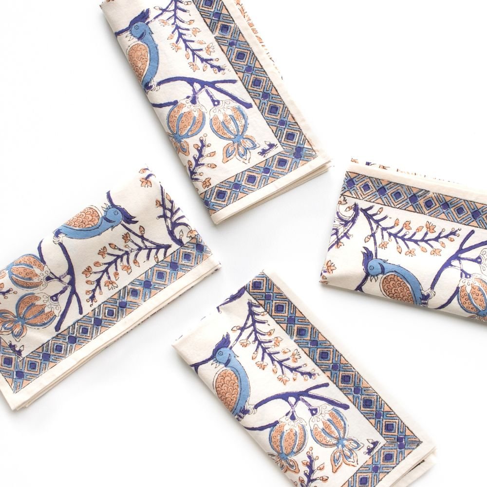 Set of decorative napkins with blue and orange patterns on a white surface