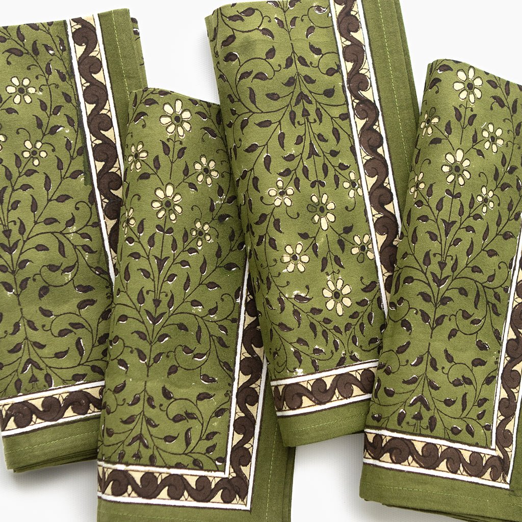 Set of green fabric swatches with floral and leaf patterns on a white background