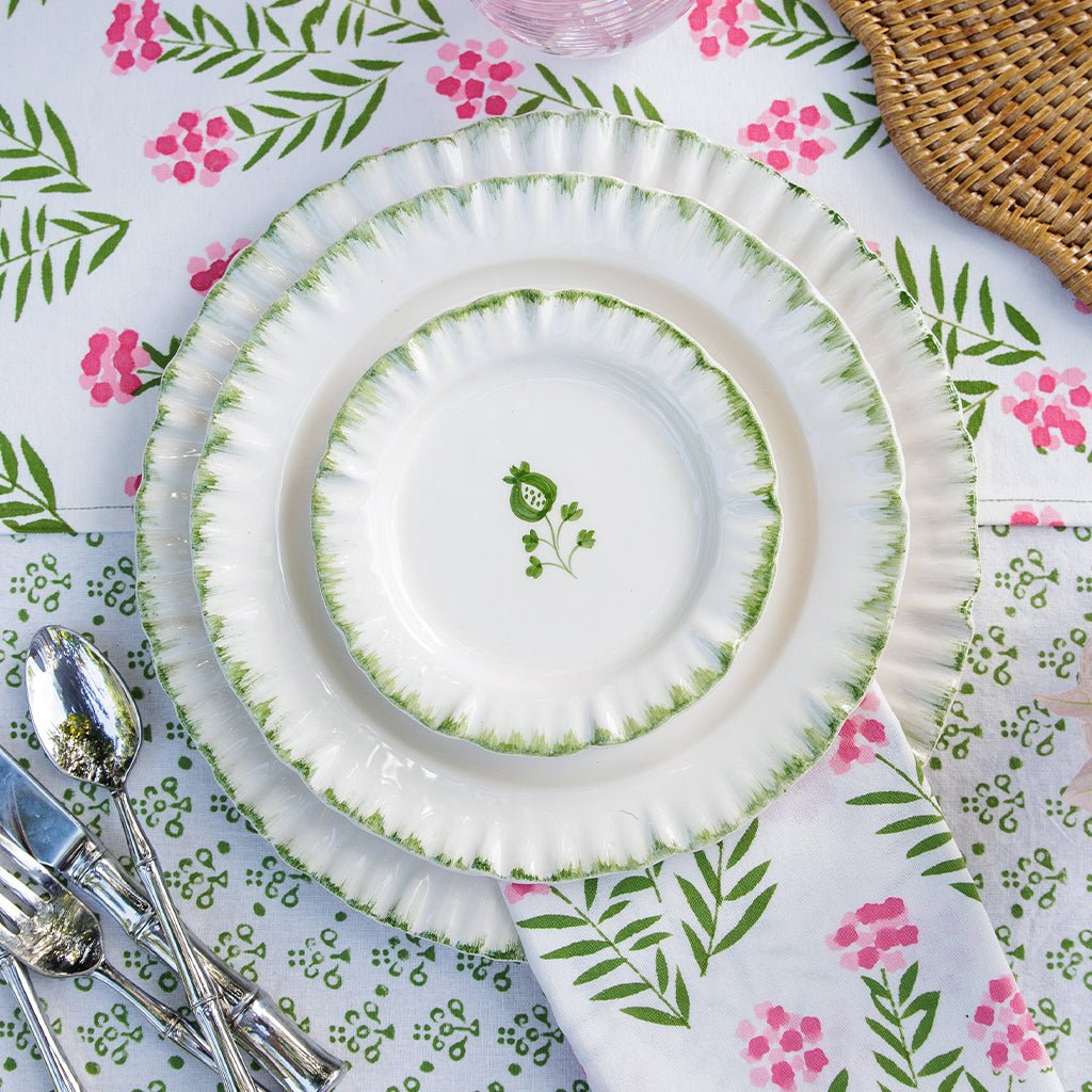 White plates with green floral patterns on a floral tablecloth