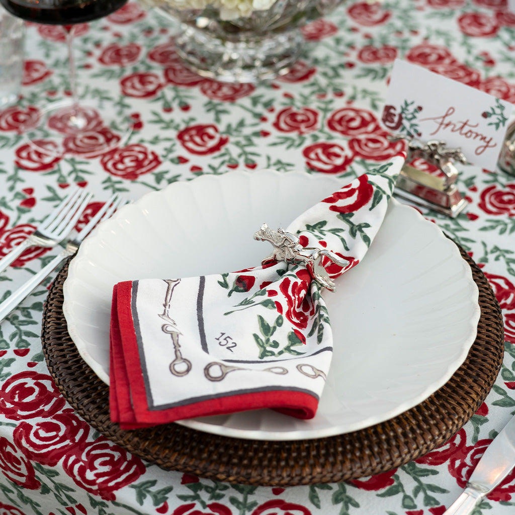 Rose patterned napkin with snaffle bit border in silver jockey napkin ring.