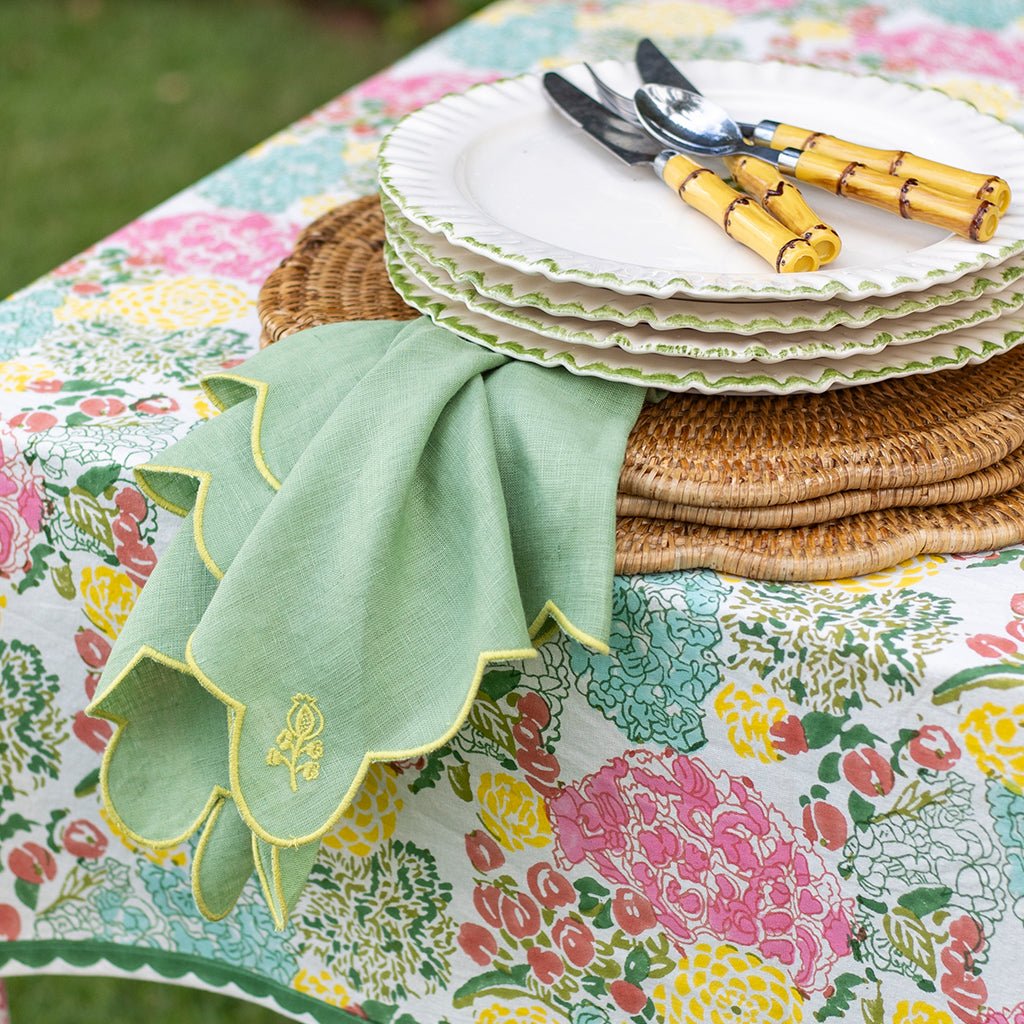 Stack of plates with cutlery on a floral tablecloth