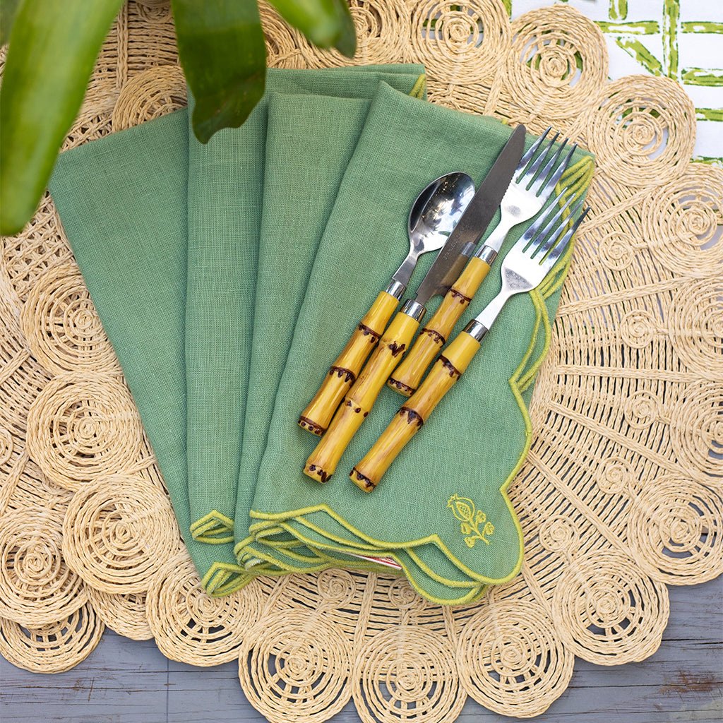 Green napkins with bamboo cutlery on a textured surface