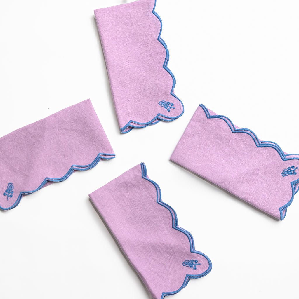 Set of purple napkins with blue edges on a white background