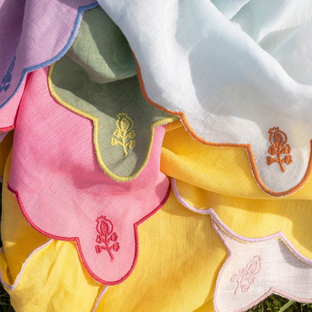 Close-up of colorful napkins with embroidered designs on a white background
