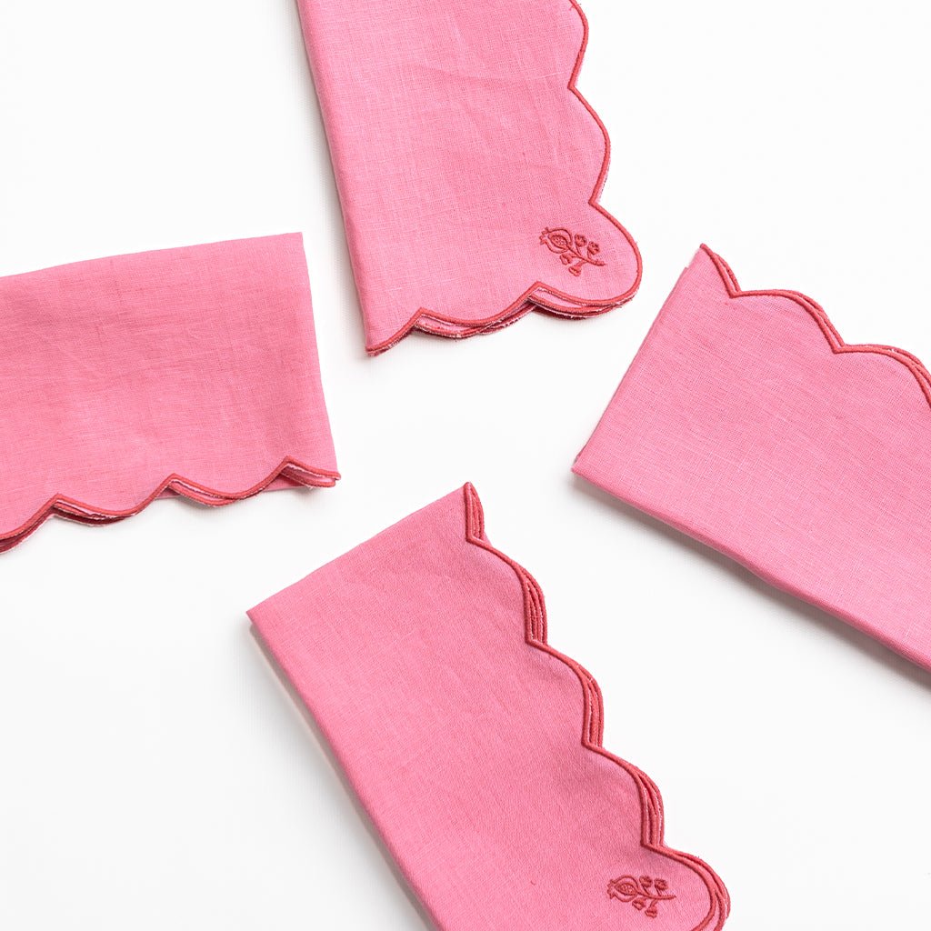 Set of pink napkins with scalloped edges on a white background