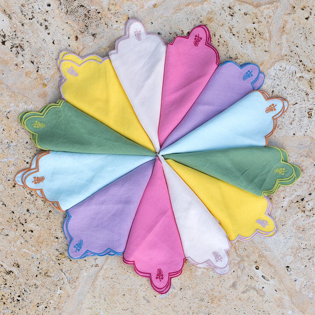 Colorful napkins arranged in a circular pattern on a textured surface.