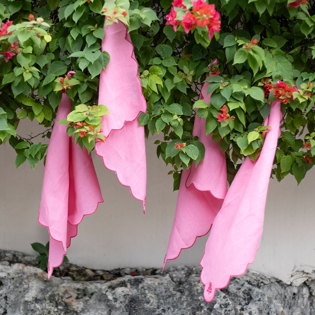 Pink linen napkins hanging in an outdoor setting.