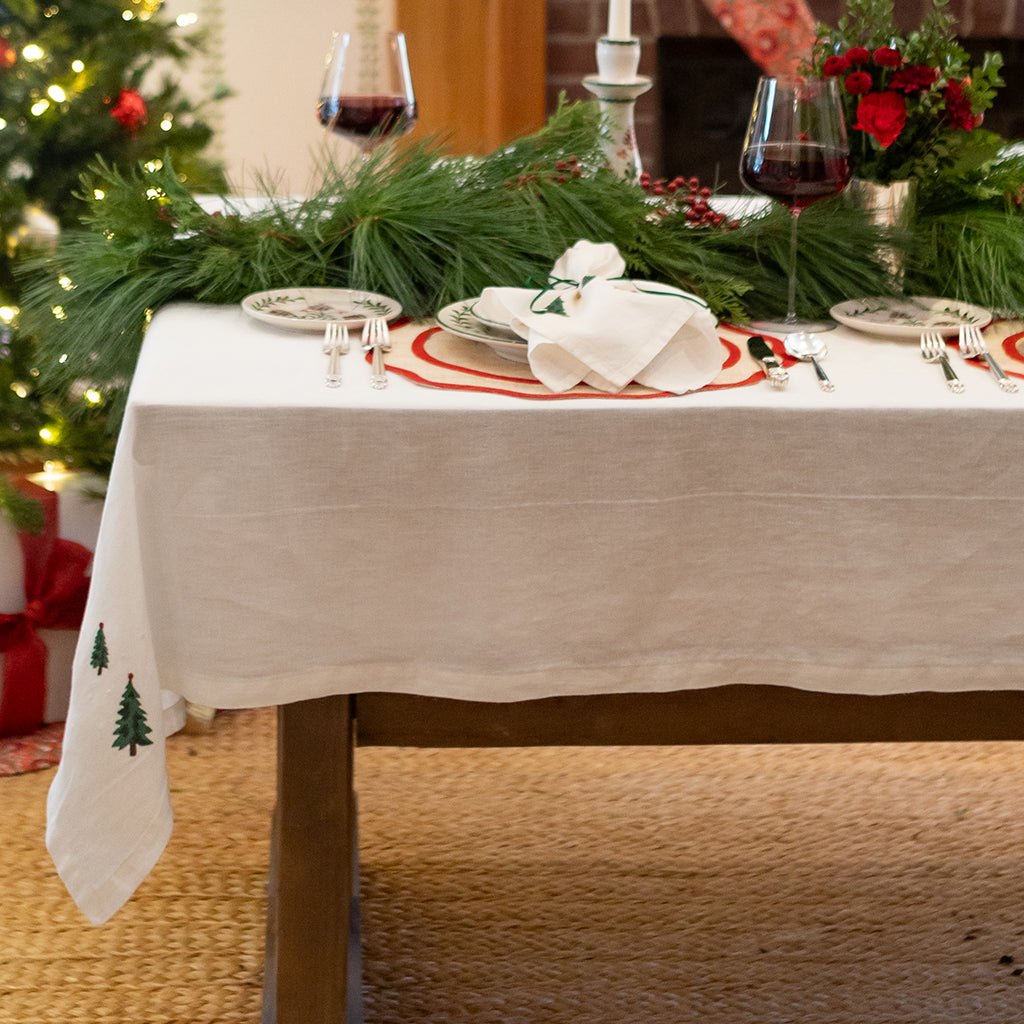 Dining table set for a festive meal with Christmas decorations.