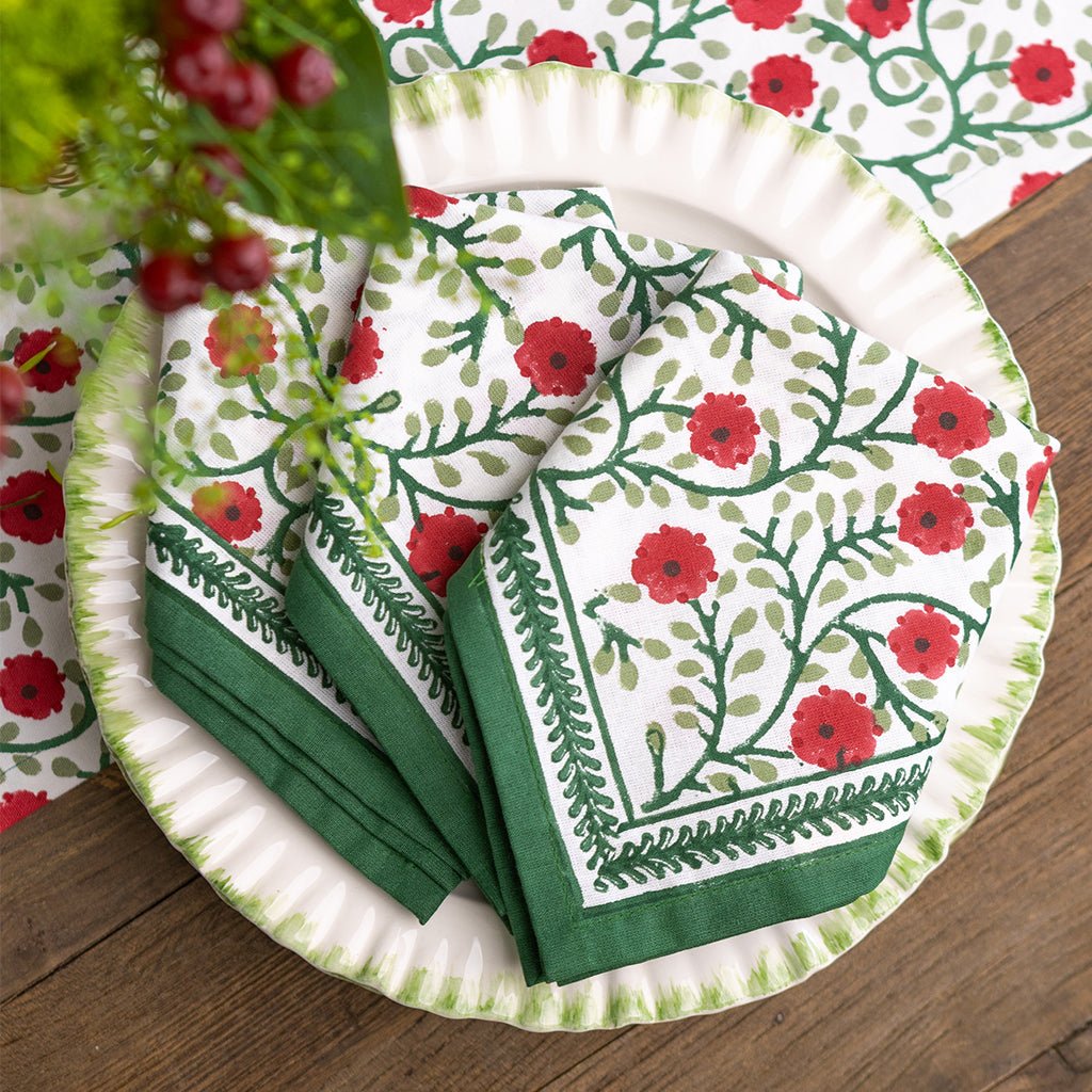 Set of paper plates and napkins with floral design on a wooden surface