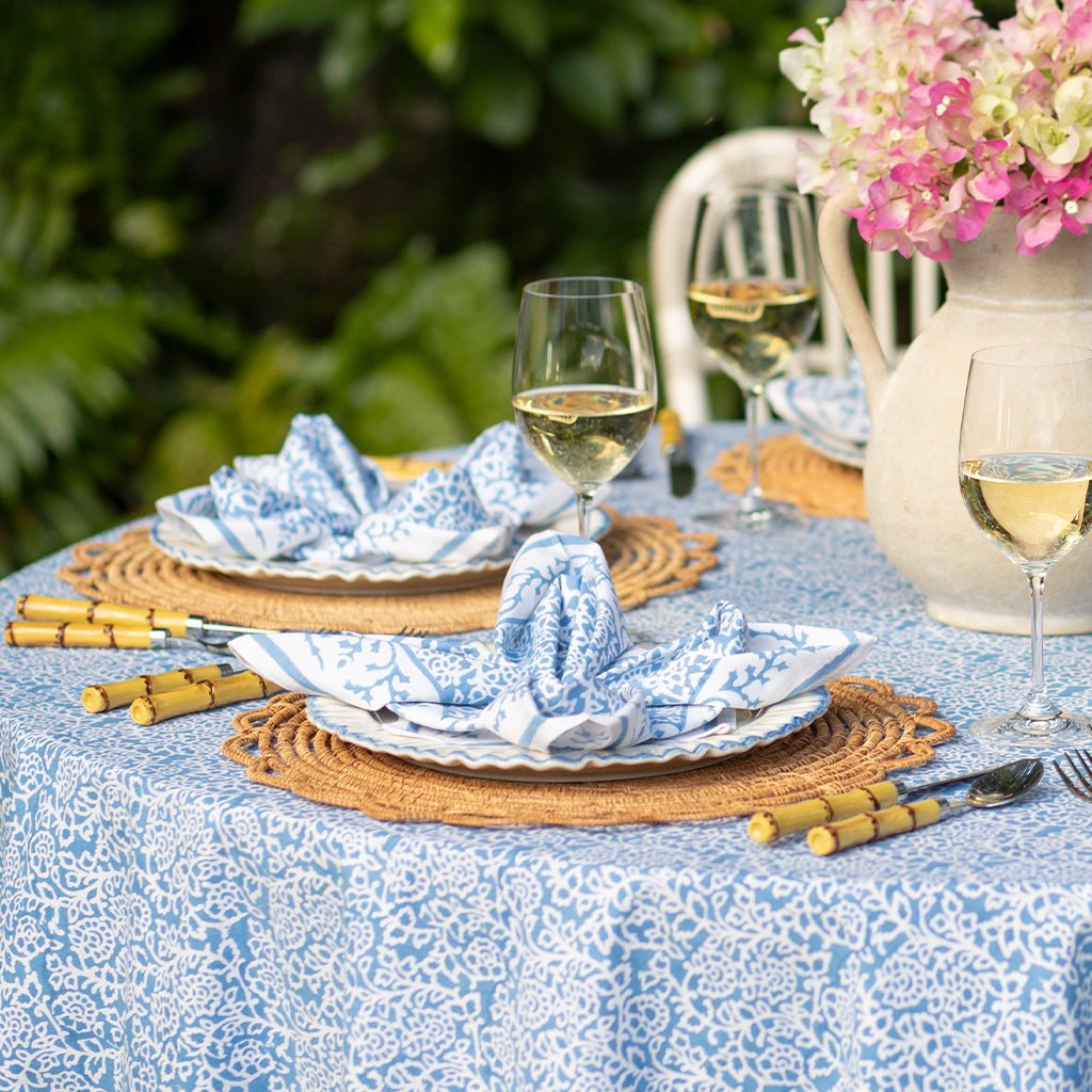 Outdoor table setting with floral decorations and white wine glasses.