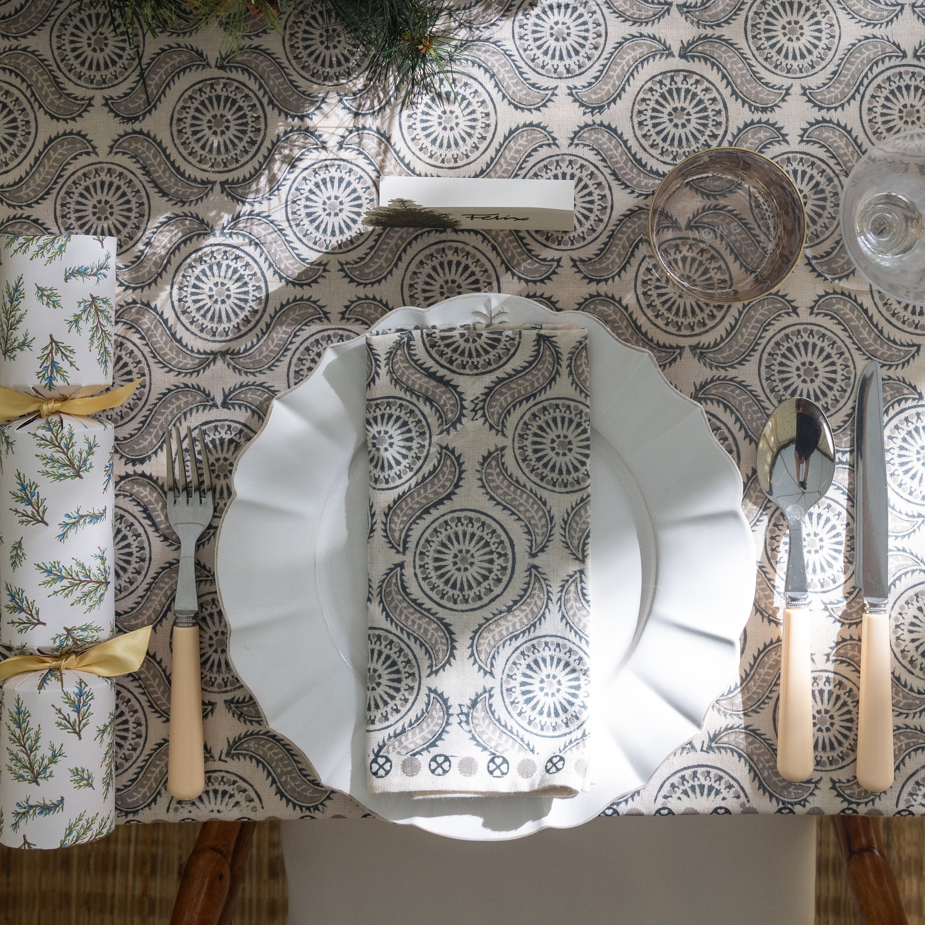 A table setting featuring a tablecloth and napkin with a geometric pattern, displayed on a table with other tableware.