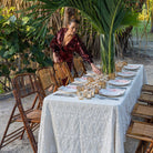 An ivory tablecloth with an embroidered diamond pattern with a tablescape set for dinner