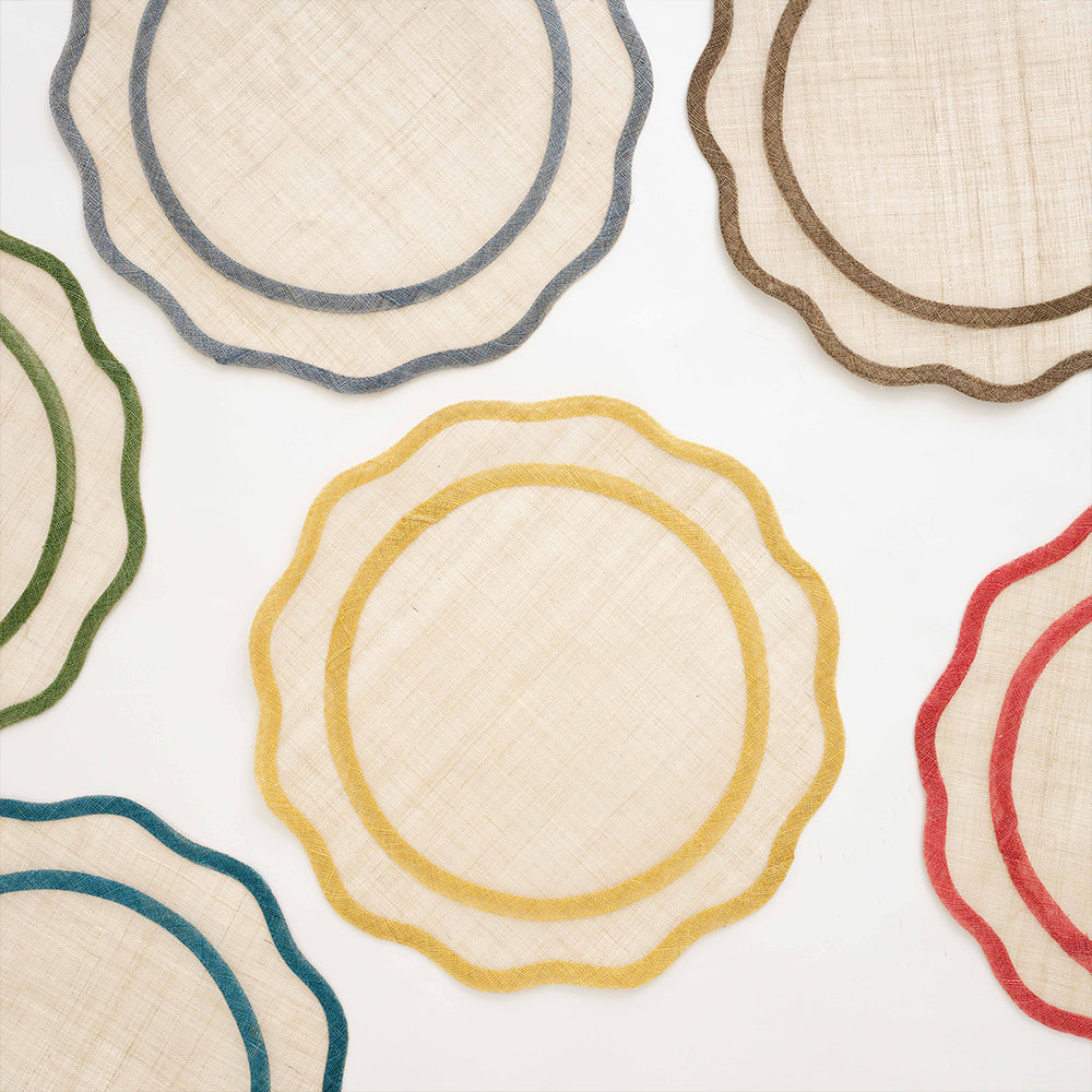 Natural fiber scalloped placemats in various colors on a white background