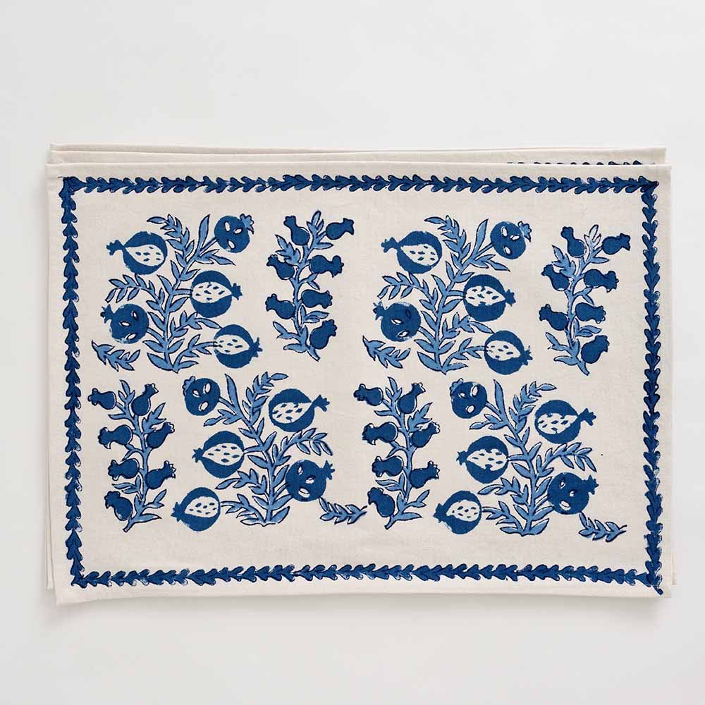 Close up of different hues of blue pomegranate pattern with leaf border.