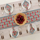 Table runner paired with matching napkin set on a dinner table. 