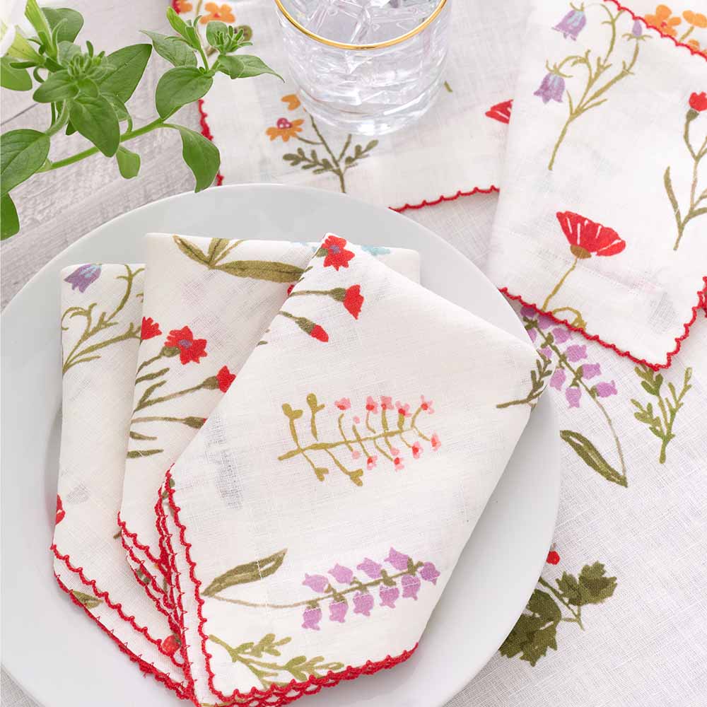 Linen napkin set with red poppy flowers, mini yellow daffodils, and lavender bluebells.