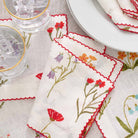 Fresh and organic floral linen napkin with red scalloped stitch.