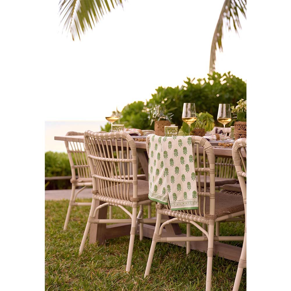 Tea towel set draped on the back of a chair at an outdoor dinner table.