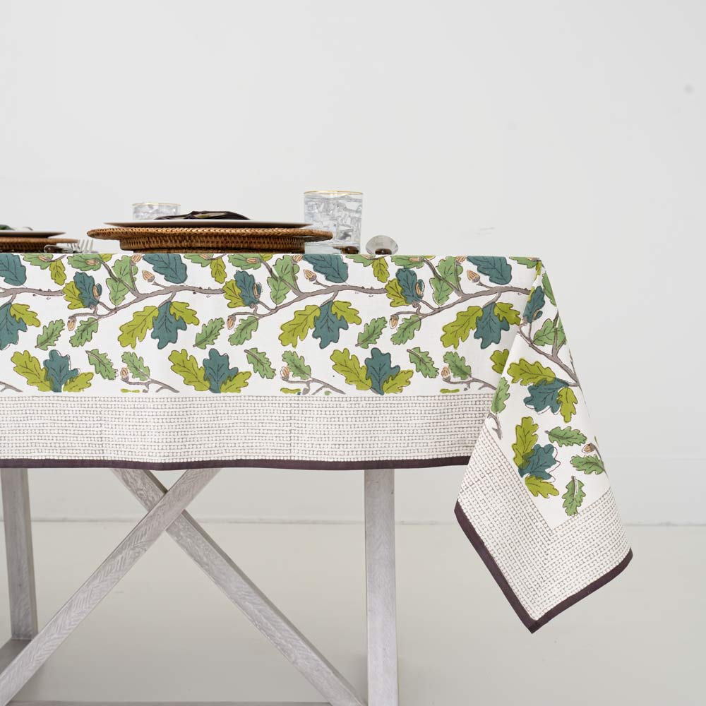 Maple leaf and acorn print tablecloth with brown and white detailed border.