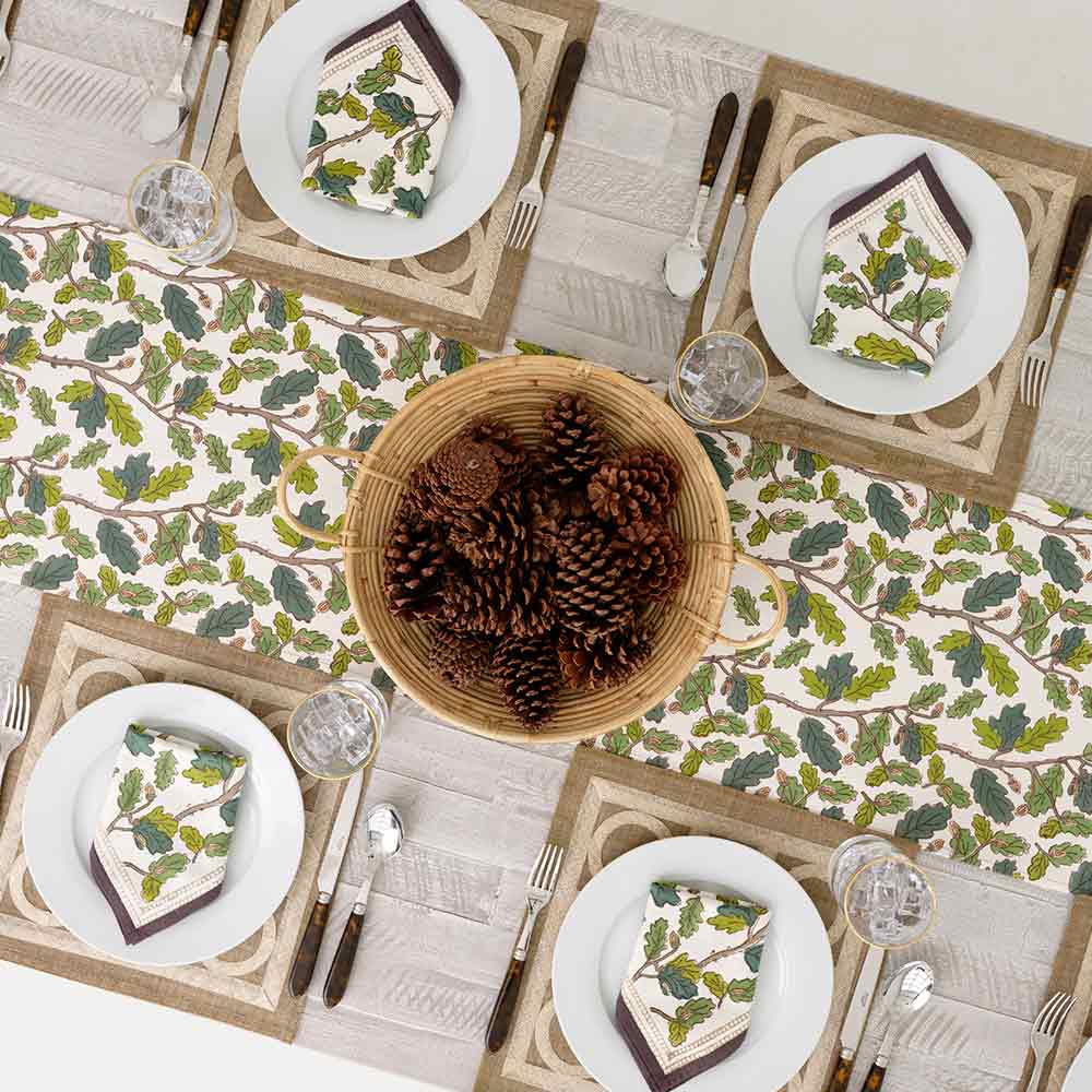 Pinecones in basket in middle of table runner.