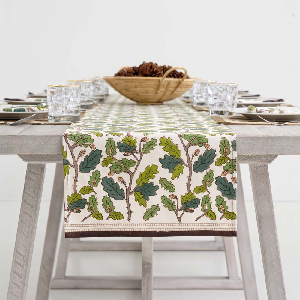 Table runner draped off side of wood table.
